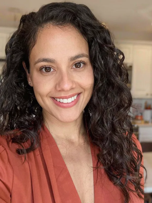 Original photo of a woman with long curly dark hair, the baseline when an AI edit changed my face