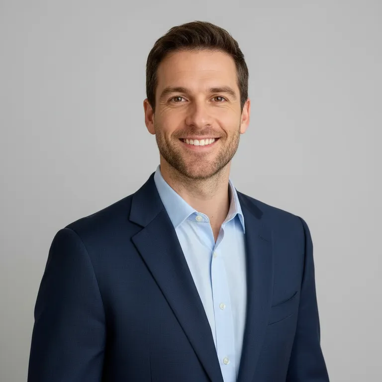 The same man as a business headshot with a plain gray background, the team style