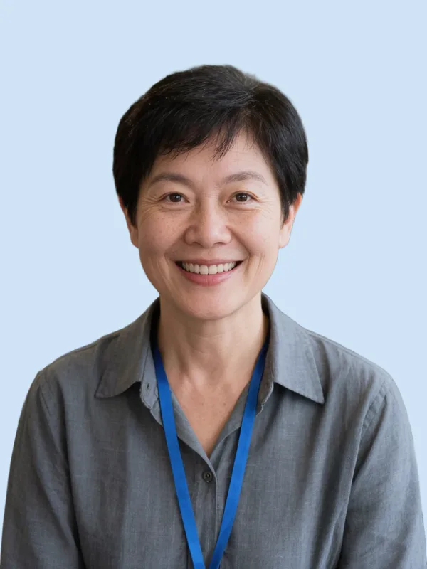 ID badge photo after: the same employee on a uniform light-blue background